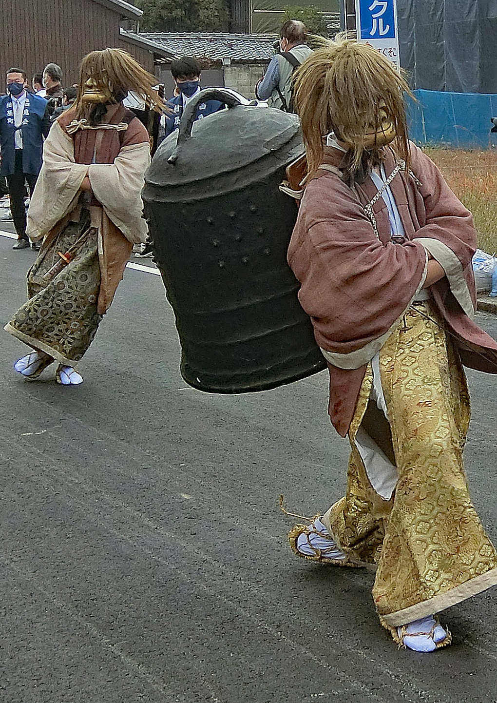 釣鐘と笈持を持ち、見物人を沸かせるひょろつき鬼2体の写真